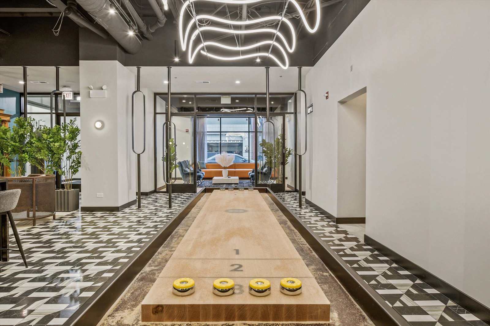Shuffleboard table with custom lighting above it.